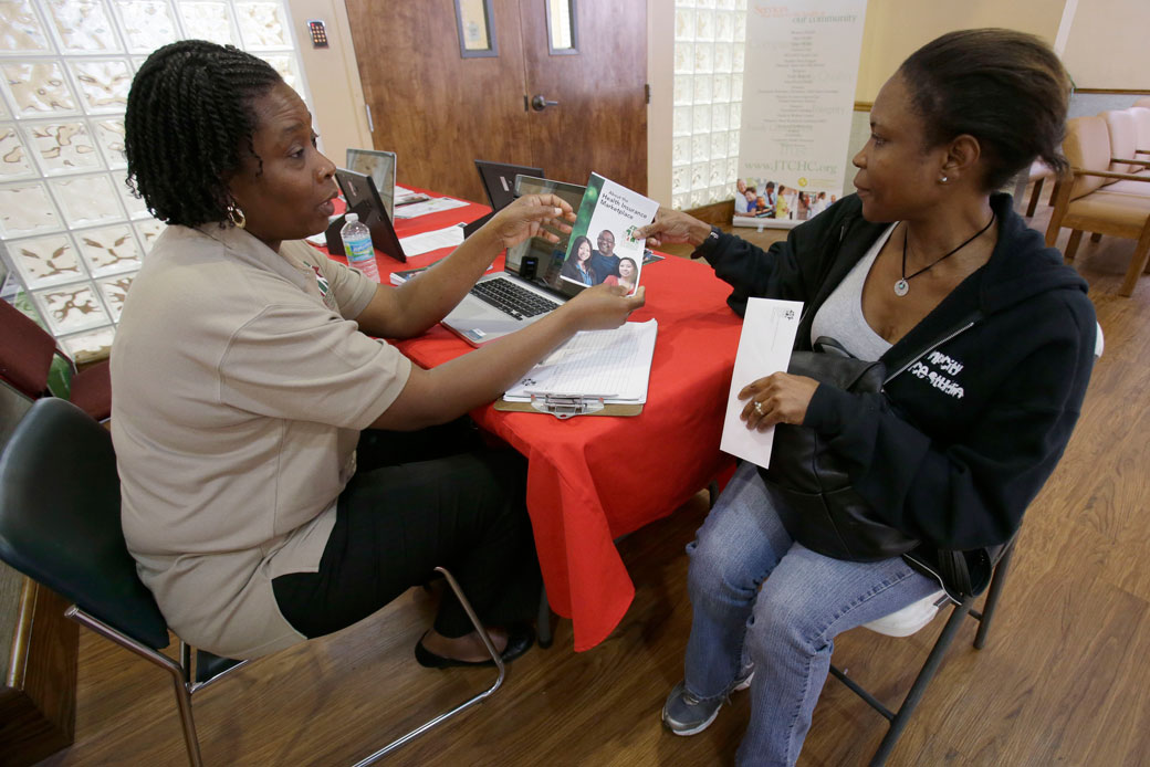 Suze Diogene, left, a certified application counselor, gives Audrey Allen information about health care, on October 1, 2013, in Miami. (AP/Wilfredo Lee)