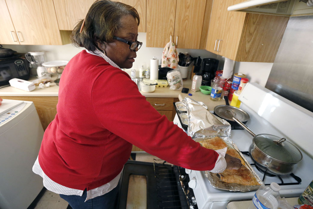 Debra Aldridge begins dinner for her and her grandson, Mario, at her home on Chicago's South Side on January 29, 2016. (AP/Charles Rex Arbogast)