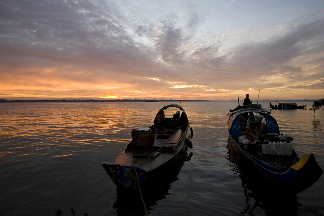 Cambodian fishermen work on their wooden boats in the early morning on the Mekong River near Phnom Penh, Cambodia, June 2010. (AP/Heng Sinith)