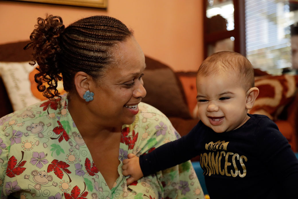 Nancy Harvey cares for a toddler in her home, which has she has converted into a child care center, in Oakland, California, October 20, 2016. (AP/Marcio Jose Sanchez)