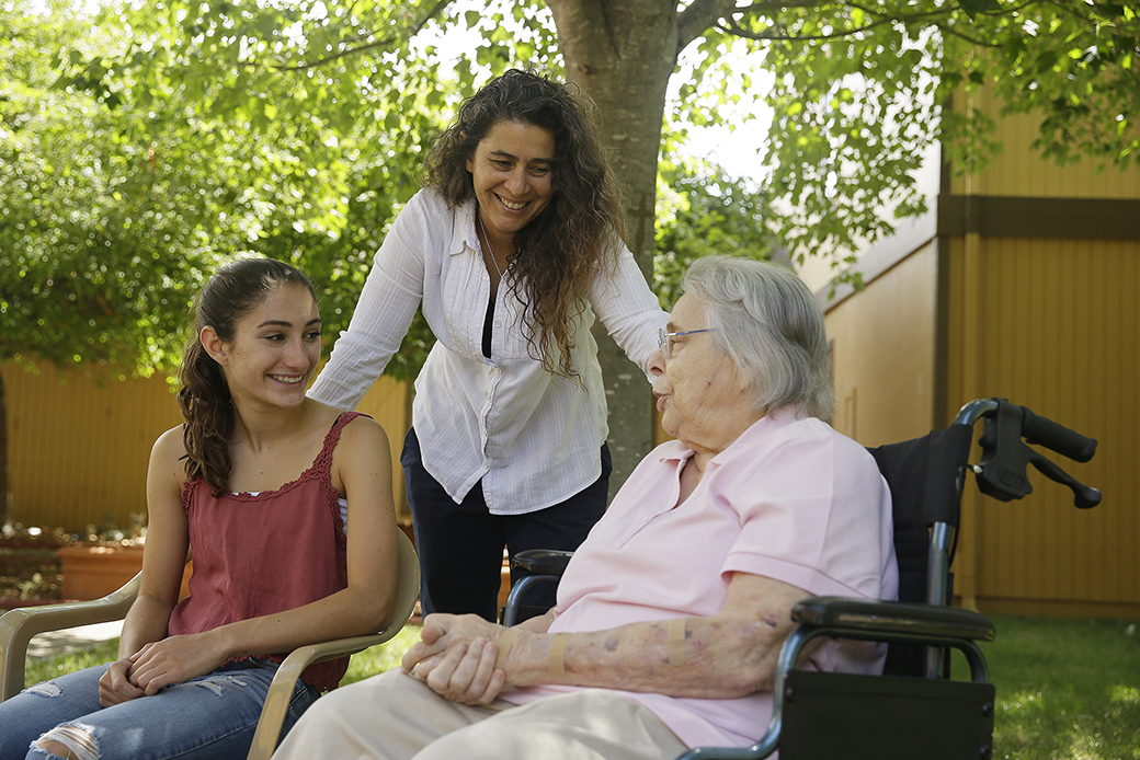 A daughter, center, visits with her mother, right, at an assisted living facility as her own daughter, left, looks on in Santa Rosa, California, July 2015. (AP/Eric Risberg)