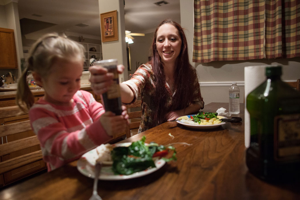 A mother helps her daughter use a pepper grinder at dinner in Austin, Texas, January 25, 2014. (AP/Tamir Kalifa)