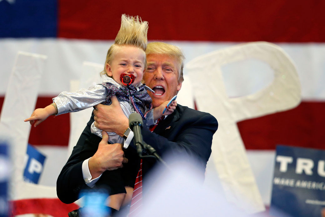 Then-Republican presidential candidate Donald Trump holds up a child he pulled from the crowd as he arrives to speak at a campaign rally in New Orleans, March 4, 2016. (AP/Gerald Herbert)
