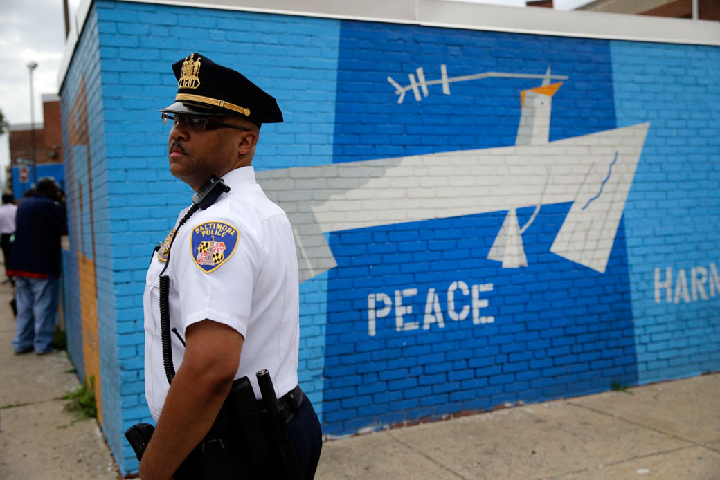 A police offer stands on a corner in the Penn North neighborhood of Baltimore, June 23, 2016. (AP/Patrick Semansky)