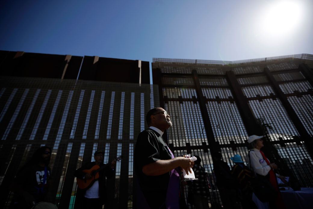 A reverend leads a song on the U.S. side of the border fence separating Tijuana, Mexico, from San Diego, April 3, 2017. (AP/Gregory Bull)