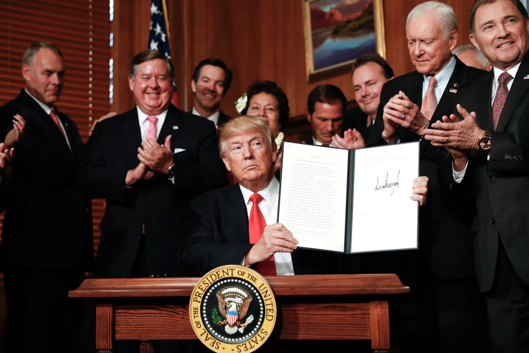 President Donald Trump holds up the signed executive order on the Antiquities Act during a ceremony at the Interior Department on April 26, 2017. (AP/Carolyn Kaster)