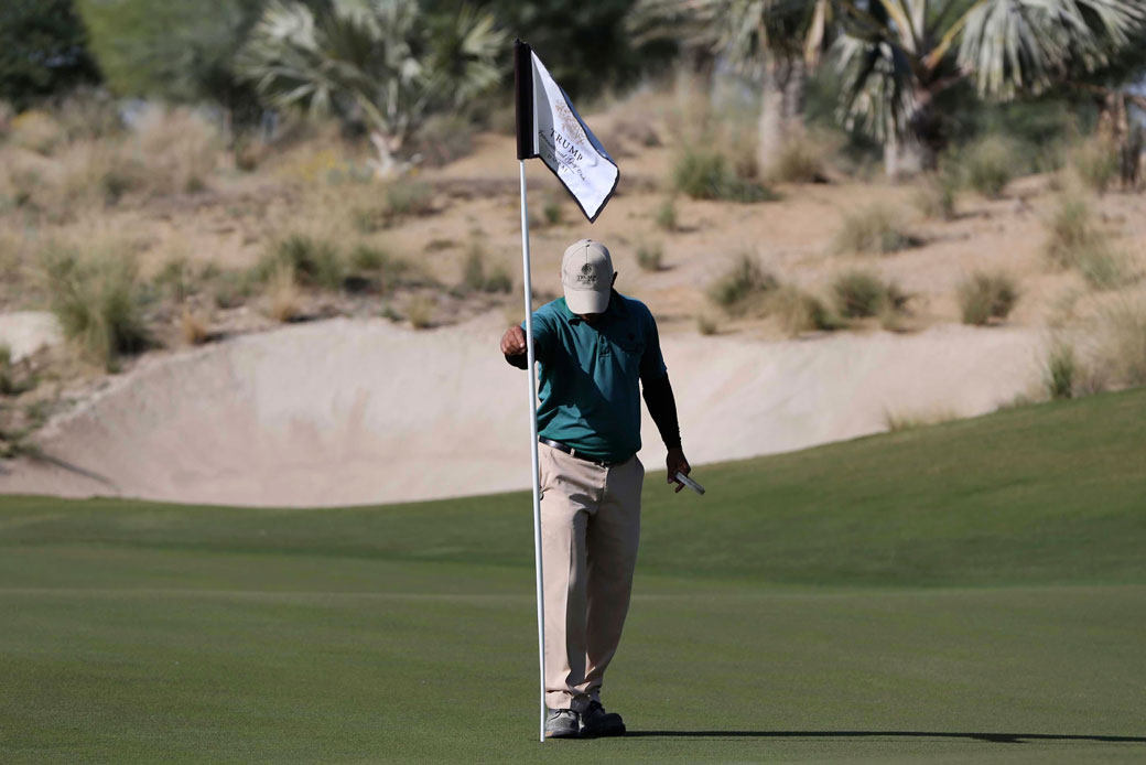 An employee fixes a flag post on the green at the Trump International Golf Club Dubai, United Arab Emirates, December 20, 2016 . (AP/Kamran Jebreili)