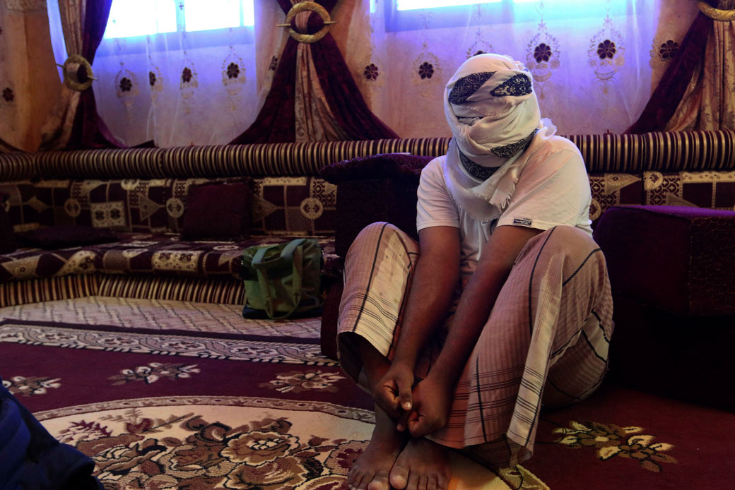 A former detainee shows how he was kept in handcuffs and leg shackles while held in a secret prison at Riyan Airport in the Yemeni city of Mukalla, May 11, 2017. (AP/Maad El Zikry)