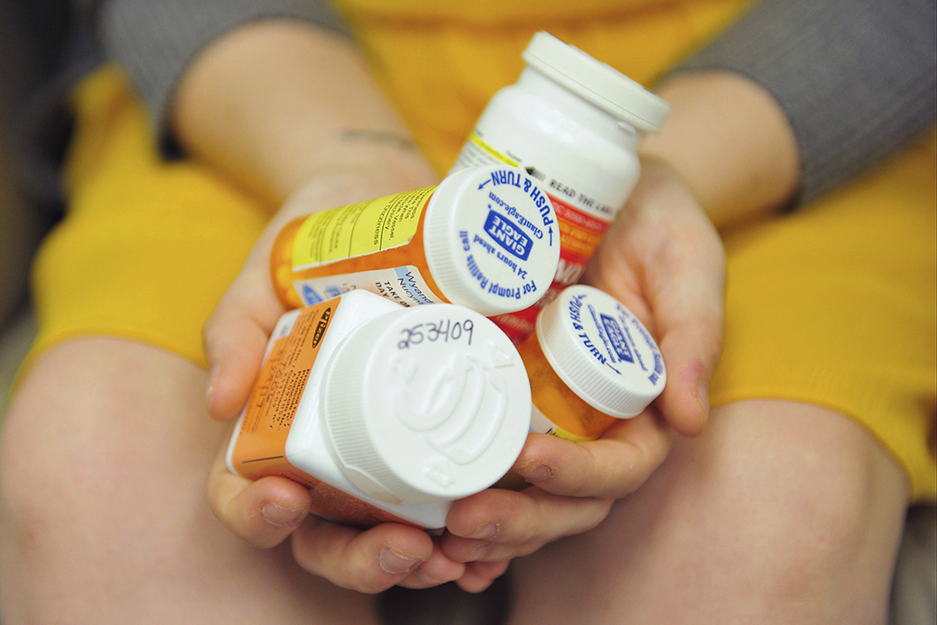 A woman holds a handful of her medication bottles at a research center in Altoona, Pennsylvania, March 29, 2017, where she is helping test an experimental nonopioid pain medication. (AP/Chris Post)
