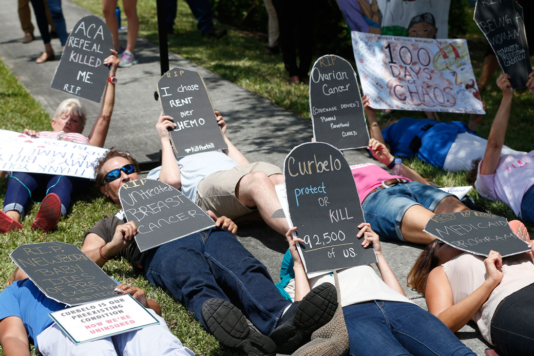Demonstrators protest during a health care demonstration outside the offices of Rep. Carlos Curbelo (R-FL), Thursday, May 4, 2017, in Miami. (AP/Wilfredo Lee)