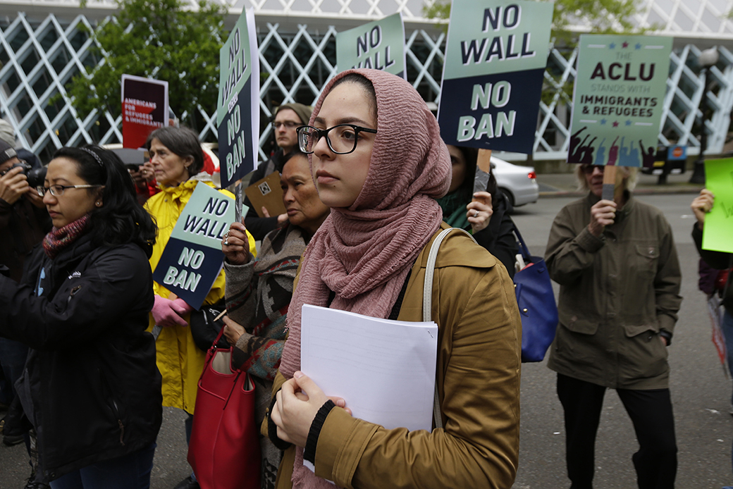 Isra Ayesh, center, of Seattle, who is the organizing director of Americans for Refugees & Immigrants, waits for her turn to speak during a demonstration against President Donald Trump's revised travel ban, May 15, 2017, outside a federal courthouse in Seattle. (AP/Ted S. Warren)
