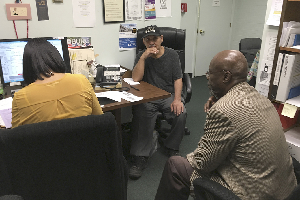 A social worker listens as an employment specialist interviews a program participant, center, at a foundation in Harrisburg, Pennsylvania, May 2017. (AP/Laurie Kellman)