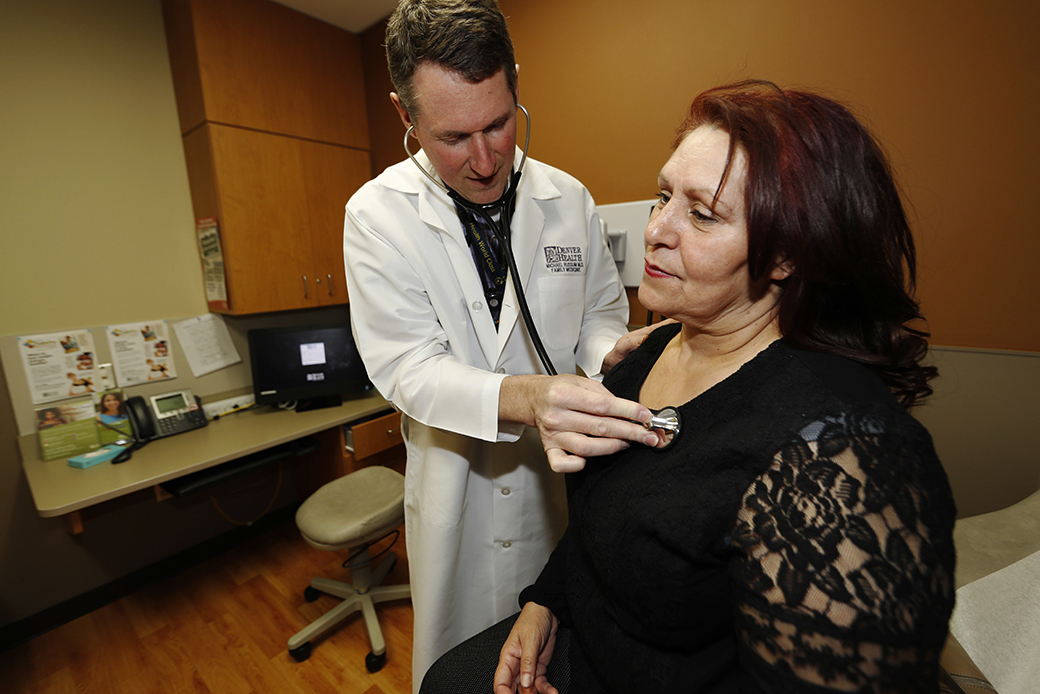 A doctor checks a patient in a primary care clinic located in a low-income neighborhood, March 2017. (AP/David Zalubowski)