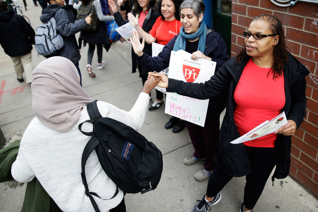 Teachers greet students as they arrive at the Science Leadership Academy in Philadelphia for the 