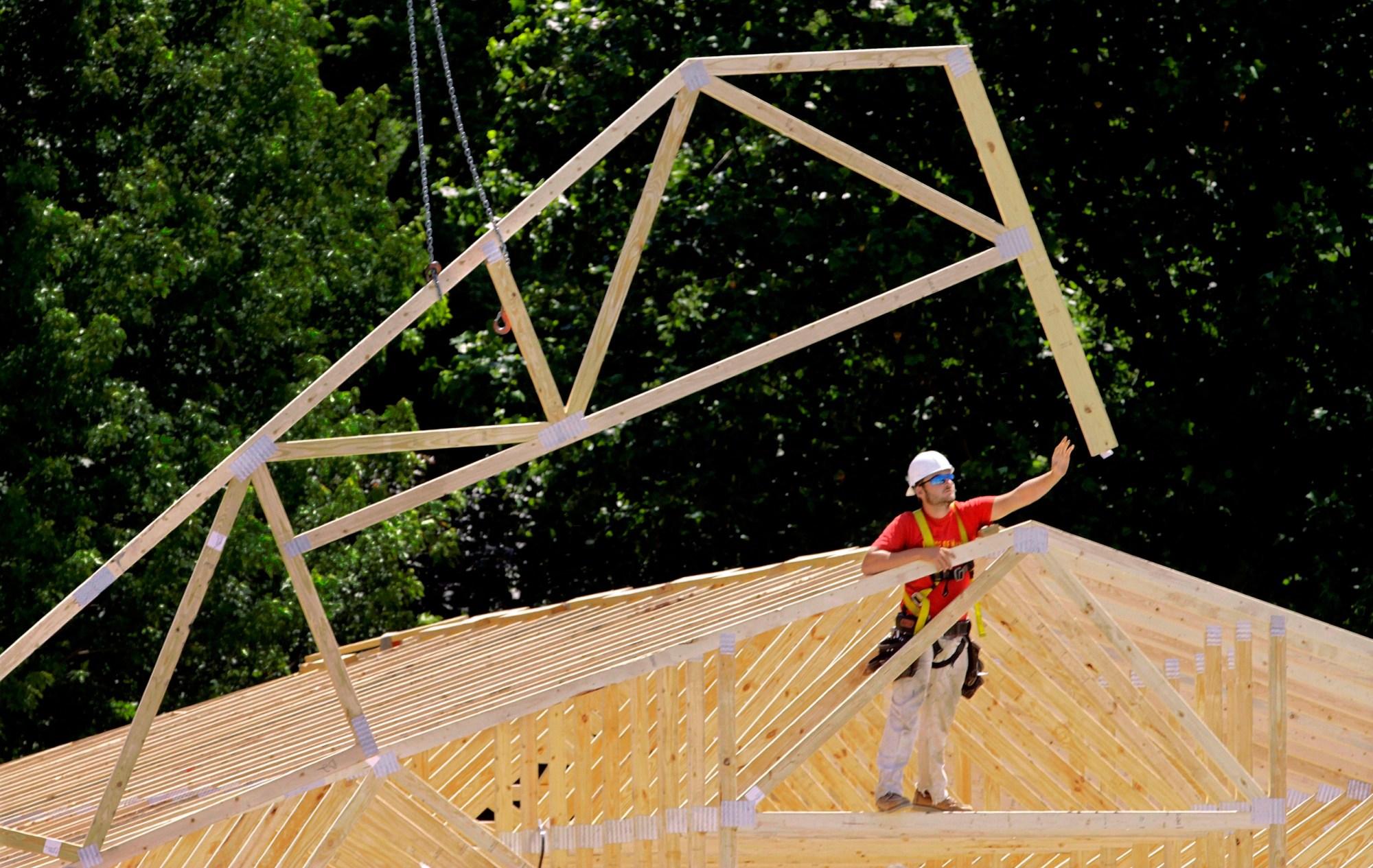 A construction worker is seen installing roofing beams on an industrial park complex in Springfield, Illinois, May 16, 2012. (AP/Seth Perlman)