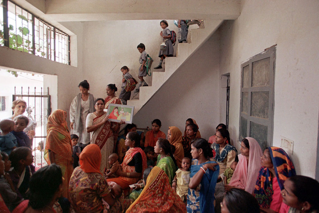 A teacher working under the guidance of USAID conducts a family planning meeting for women in the Sangam Vihar area of New Delhi, August 1999. (AP/John McConnico)