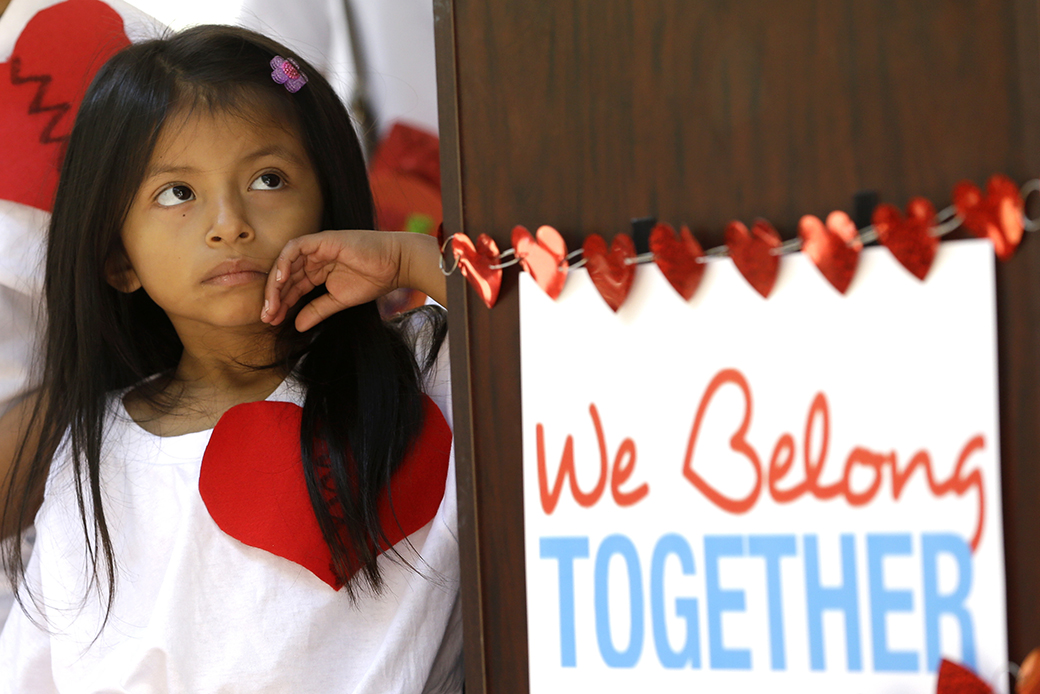 The young daughter of illegal immigrant parents stands next to a sign outside the Miami-Dade County building, February 14, 2017, in downtown Miami. (AP/Alan Diaz)