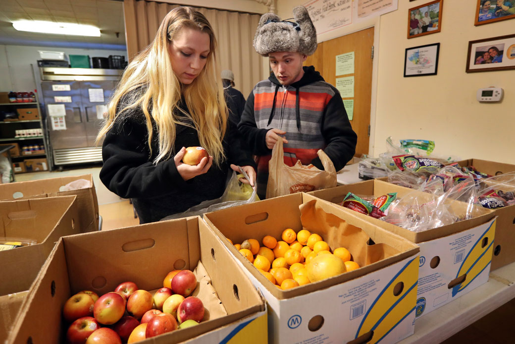In this March 27, 2017, photo Sunny Larson, left, and Zak McCutcheon pick produce while gathering provisions to take home at the Augusta Food Bank in Augusta, Maine. (AP/Robert F. Bukaty)