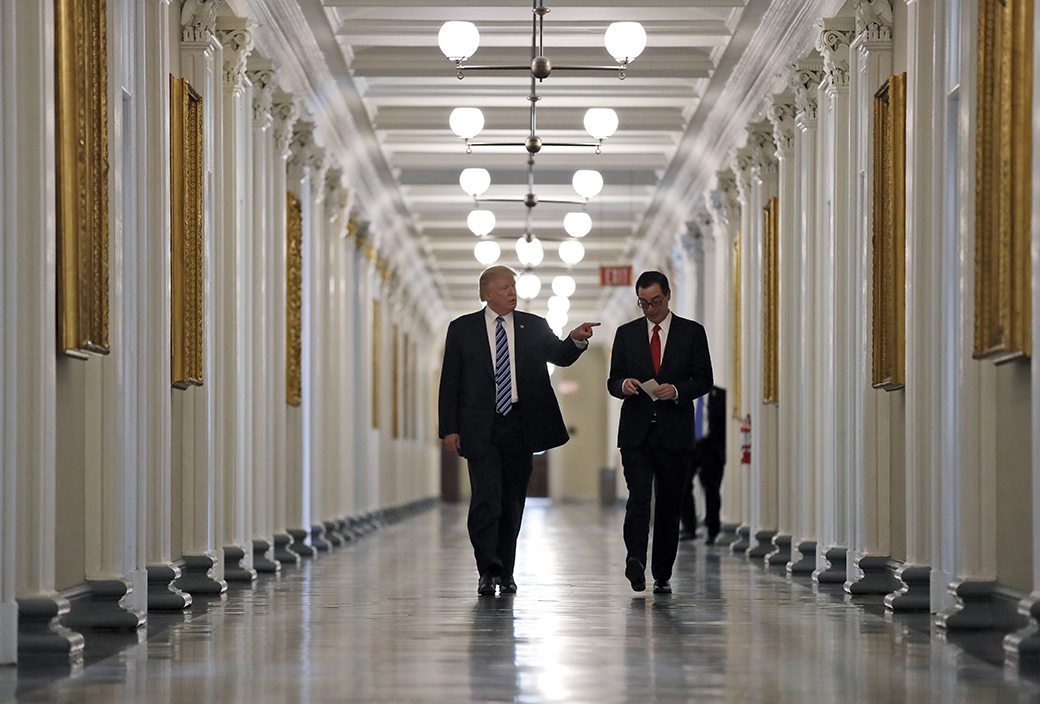 President Donald Trump walks with Treasury Secretary Steven Mnuchin as they look at portraits of the previous secretaries of the Treasury, April 21, 2017, at the Treasury Department in Washington. (AP/Alex Brandon)