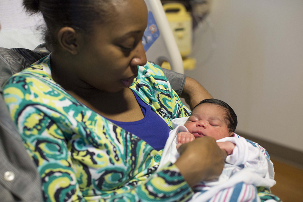 A woman holds her newborn daughter in her hospital room at Prentice Women's Hospital in Chicago, June 7, 2013. (AP/Scott Eisen)