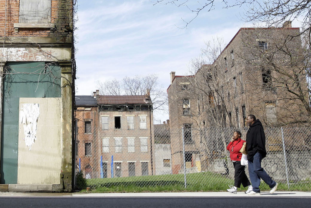 A couple walks past abandoned buildings in a poor, urban neighborhood in Cincinnati, Ohio, on April 11, 2009. (AP/Al Behrman)