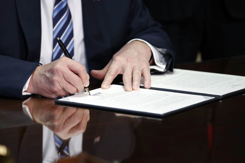 President Donald Trump signs an executive order at the U.S. Treasury Department in April 2017. (AP/Alex Brandon)