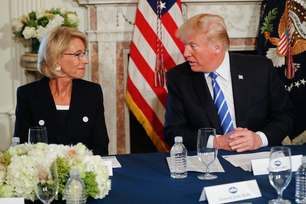 President Donald Trump looks toward Education Secretary Betsy DeVos, as he speaks during a  discussion at Trump National Golf Club in Bedminster, New Jersey, August 11, 2017. (AP/Pablo Martinez Monsivais)