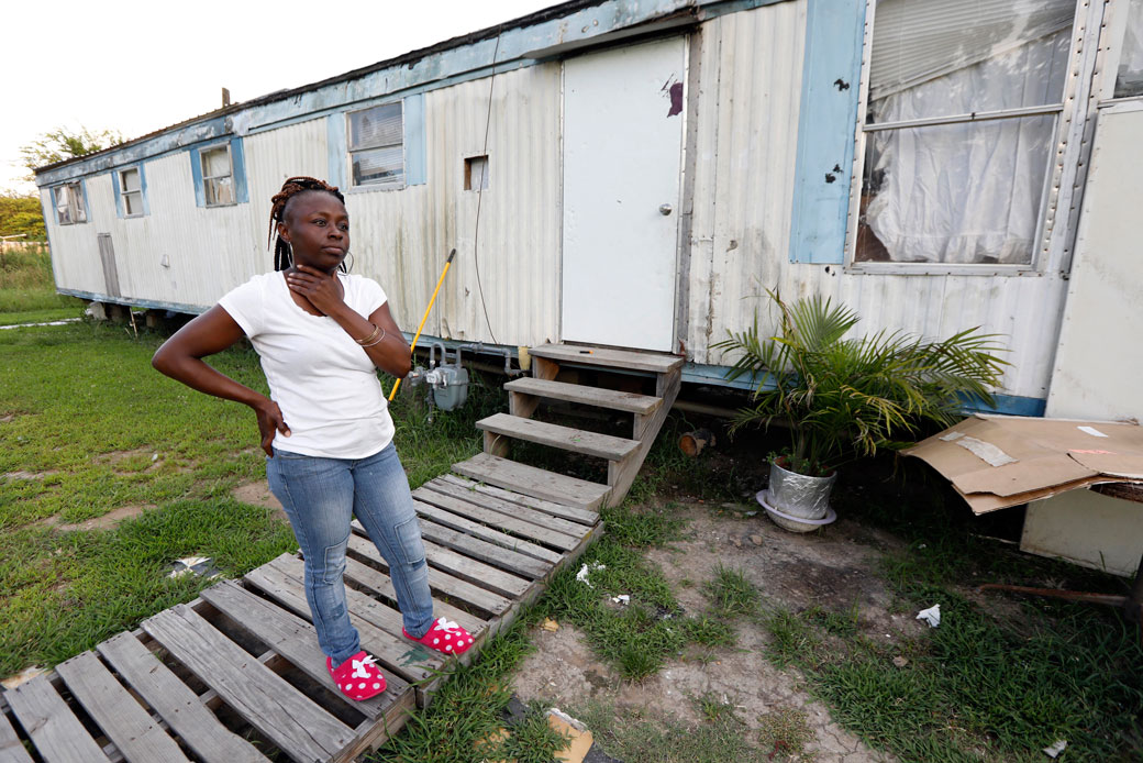 In this July 24, 2017, photograph, Otibehia Allen, a single mother of five, stands outside her rented mobile home in Jonestown, Mississippi. Allen works 30 hours a week as a data entry clerk and transportation dispatcher for a medical clinic, pulling in barely more than minimum wage. (AP/Rogelio V. Solis)