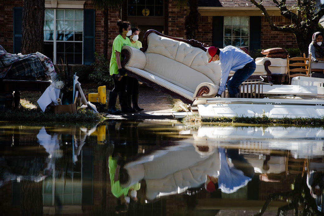 Sohail Soomro, center right, accompanied by his family, dumps flood damaged furniture on his front yard in the aftermath of Hurricane Harvey on Thursday, September 7, 2017, at the Canyon Gate community in Katy, Texas. (AP/Matt Rourke)