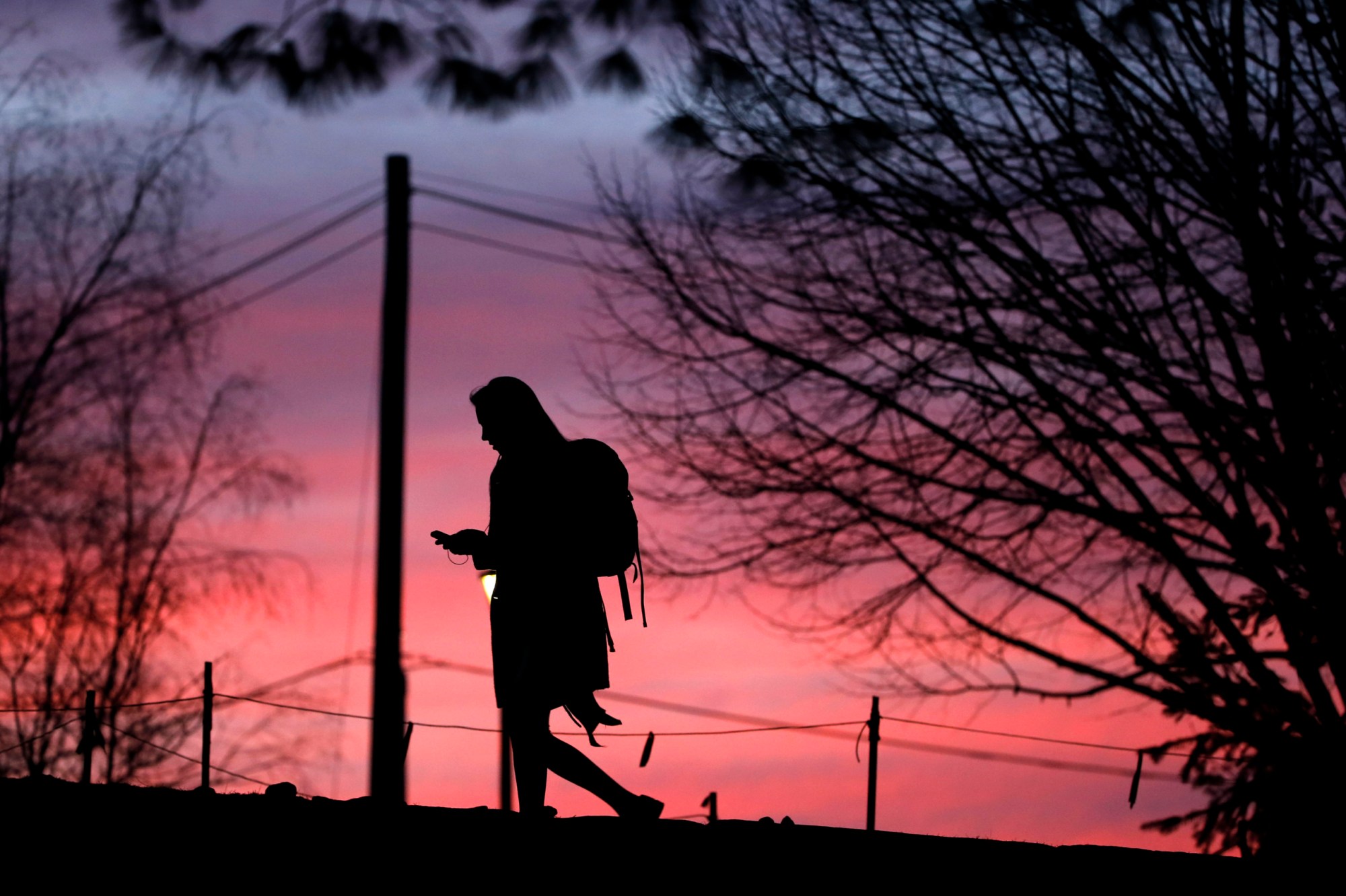 A University of New Hampshire student walks across campus as the sun sets Thursday, Feb. 4, 2016, in Durham, New Hampshire. (AP/Matt Rourke)