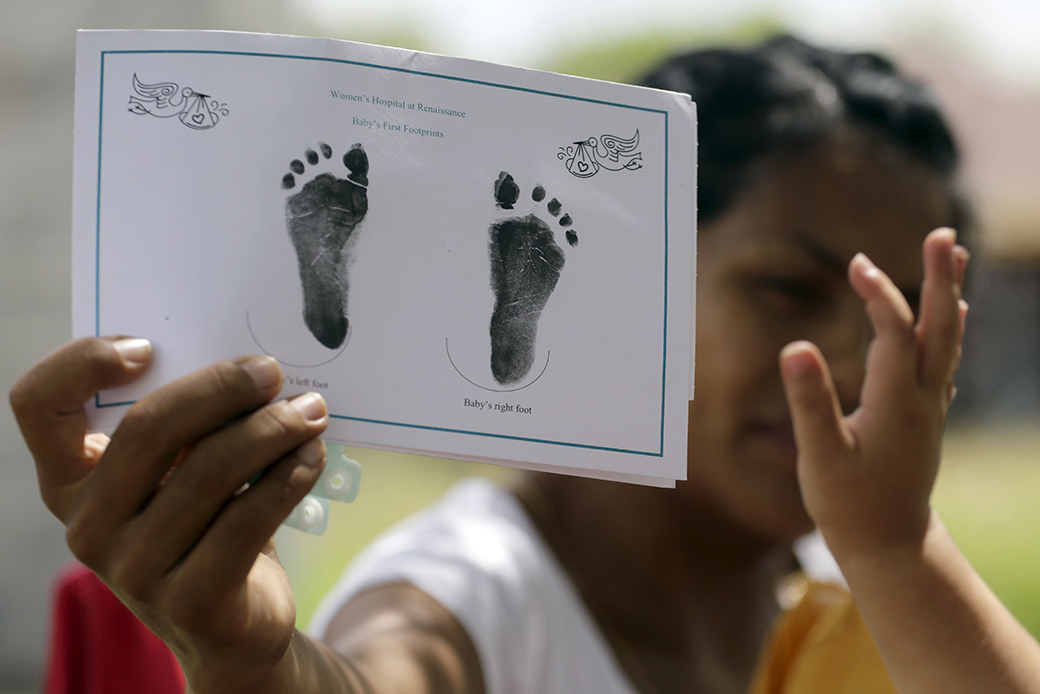 A woman shows the footprints of her daughter, reaching into photo,  in Texas, September 2015. (AP/Eric Gay)