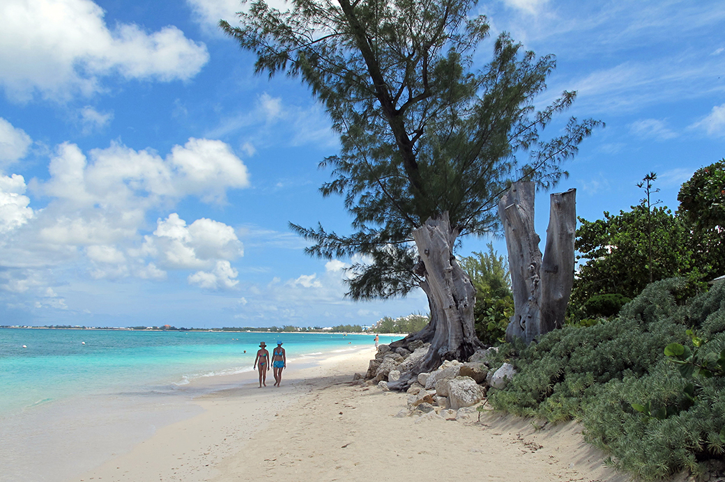 Tourists walk along the shore of Seven Mile Beach in Grand Cayman Island, August 2012. (AP/David McFadden)