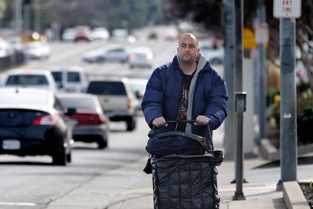 A California Medicaid recipient pushes his cart of belongings along a street in Sacramento, February 11, 2015. (AP/Rich Pedroncelli)