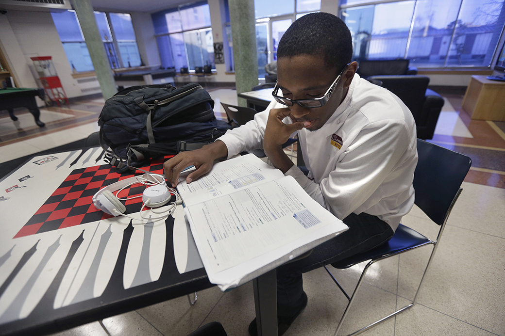 A student studies in a common area on his college campus, February 2013. (AP/Gerald Herbert)