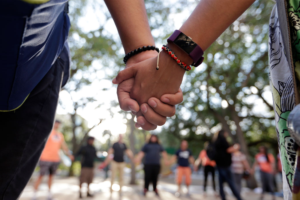 Immigrant rights supporters join hands as they demonstrate in favor of Congress passing a clean Dream Act that will prevent the deportation of young immigrants known as Dreamers working and studying in the United States, October 13, 2017, in Miami. (AP/Lynne Sladky)