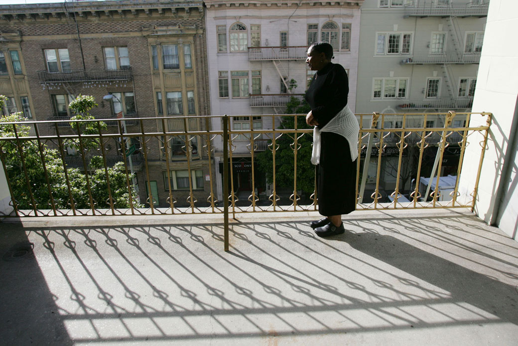 A woman looks out to the street from a balcony in San Francisco, February 2005. (AP/Marcio Jose Sanchez)