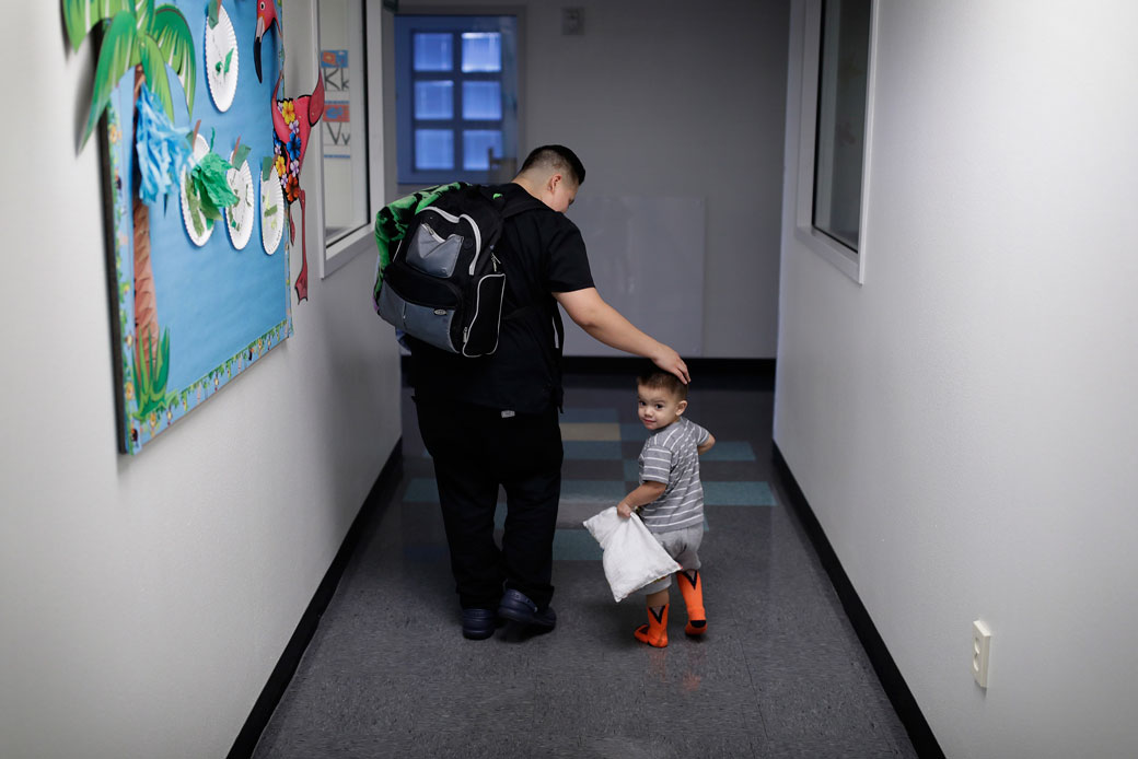 A mother picks up her 2-year-old son at a child development center in Las Vegas. (AP/John Locher)