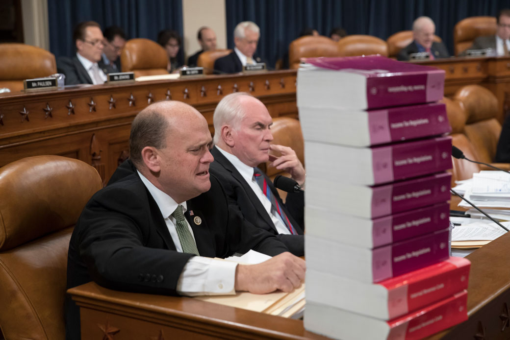 Rep. Tom Reed (R-NY) and Rep. Mike Kelly (R-PA) sit behind a stack of tax volumes on Capitol Hill, November 8, 2017. (AP/J. Scott Applewhite)