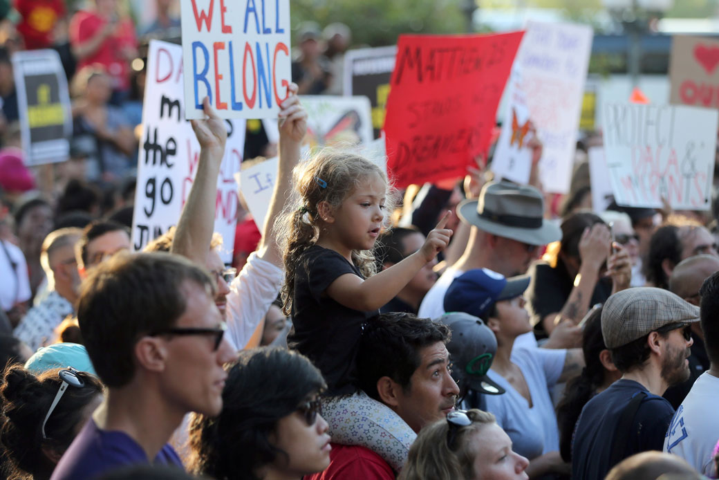 A child sits on a man's shoulders among demonstrators in favor of Deferred Action for Childhood Arrivals during a protest at the historic Plaza de Los Angeles on September 5, 2017. (AP/Reed Saxon)