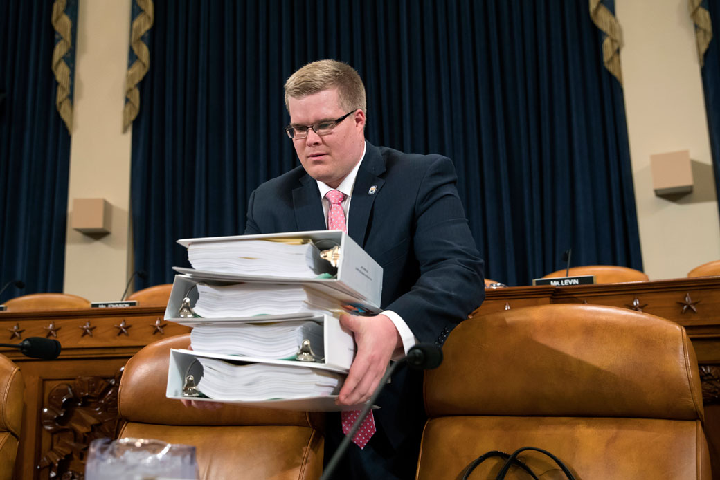 Copies of the proposed Republican tax package are carried by a House Ways and Means Committee staffer before the start of the markup session on the bill, on Capitol Hill in Washington, Monday, November 6, 2017. (AP/J. Scott Applewhite)