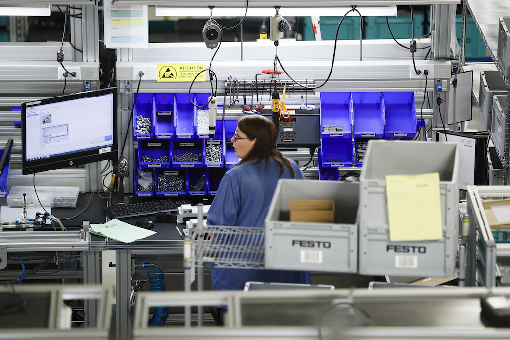 An employee in Mason, Ohio, stands at her workstation, May 2017. (AP/John Minchillo)