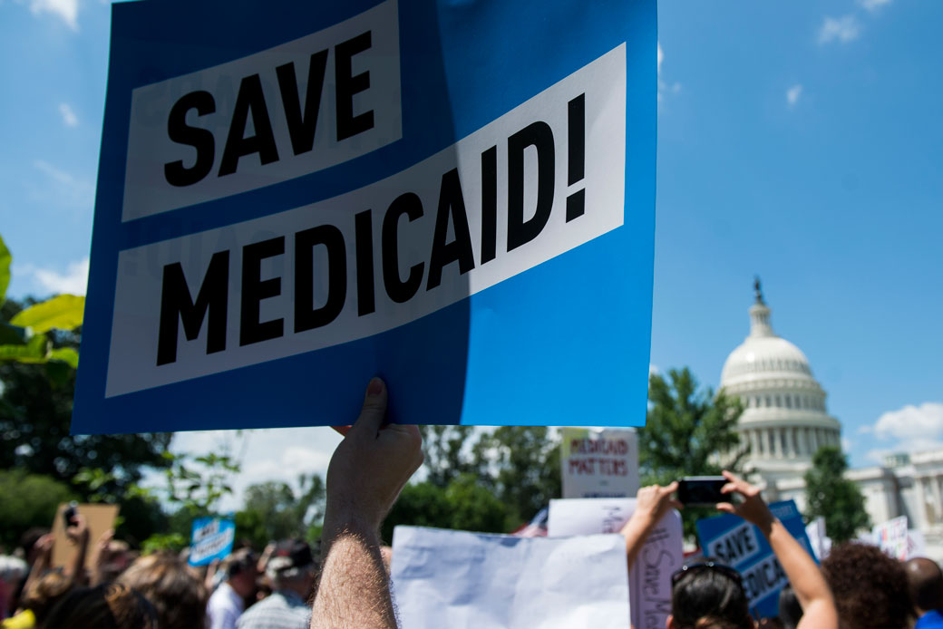 Participants hold signs during the Senate Democrats' rally against Medicaid cuts in front of the U.S. Capitol, June 2017. (Getty/Bill Clark)
