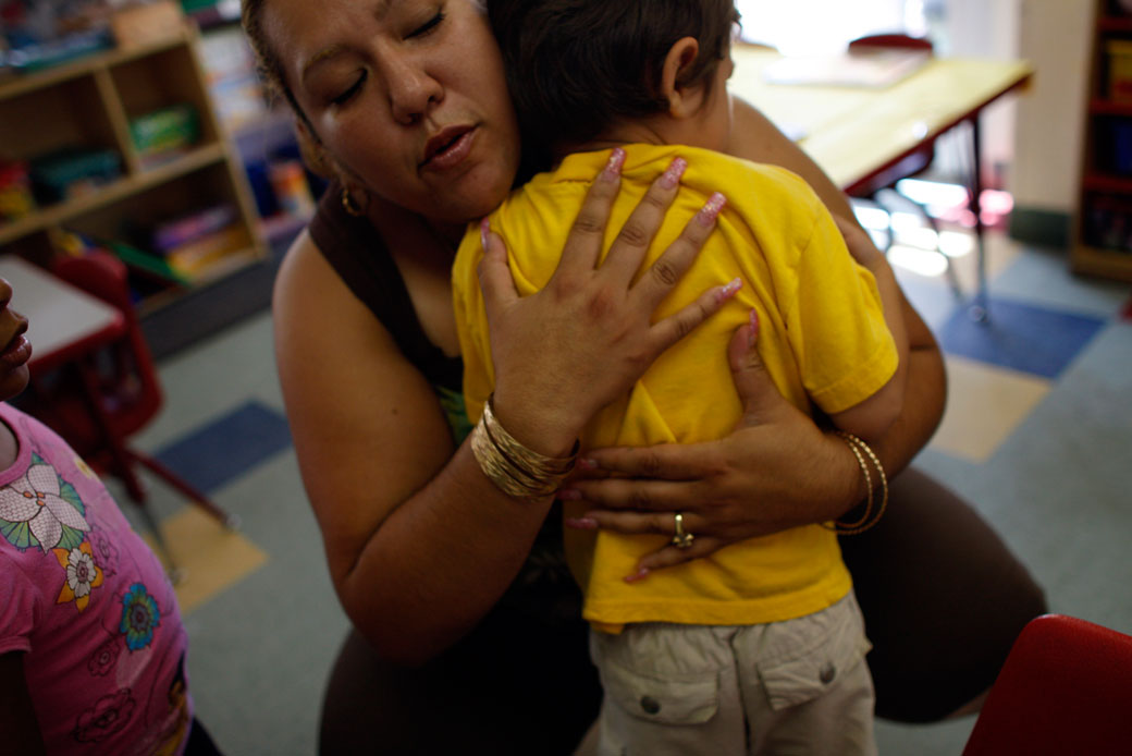 A child care worker in South Los Angeles hugs a crying child during an exercise period, September 2010. (Getty/Los Angeles Times, Michael Robinson Chavez)