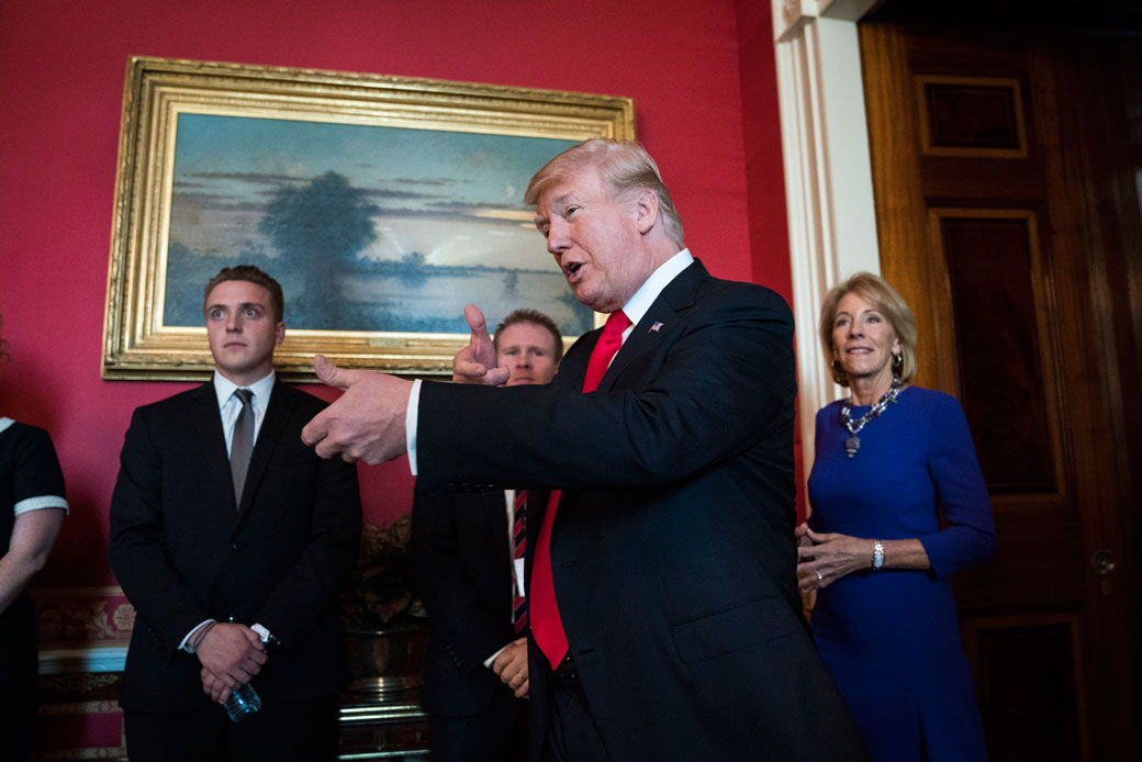 President Donald Trump, with Secretary of Education Betsy DeVos, gestures as he walks, November 2017 (Getty/Jabin Botsford)