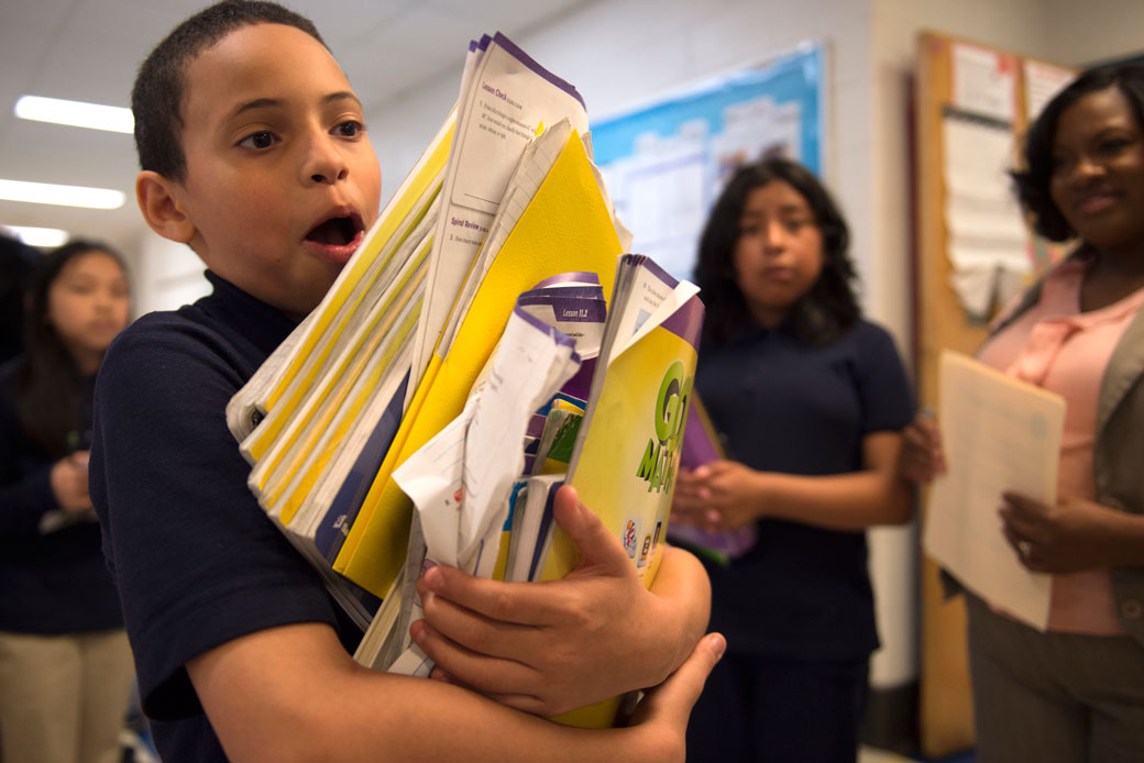 A Philadelphia middle school student carries a stack of books from class, May 2016. (Getty/The Washington Post/Nikki Kahn)