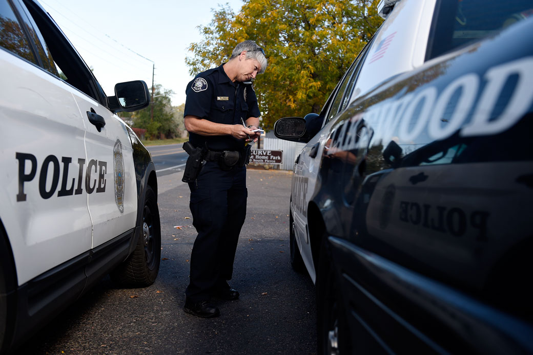 A police officer talks with a superior officer on the phone. (Getty/Seth McConnell)