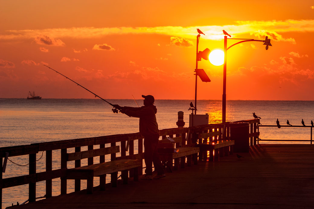 An angler casts from a pier as the sun sets on St. Simons Island, Georgia. (Getty/Bob Pool)