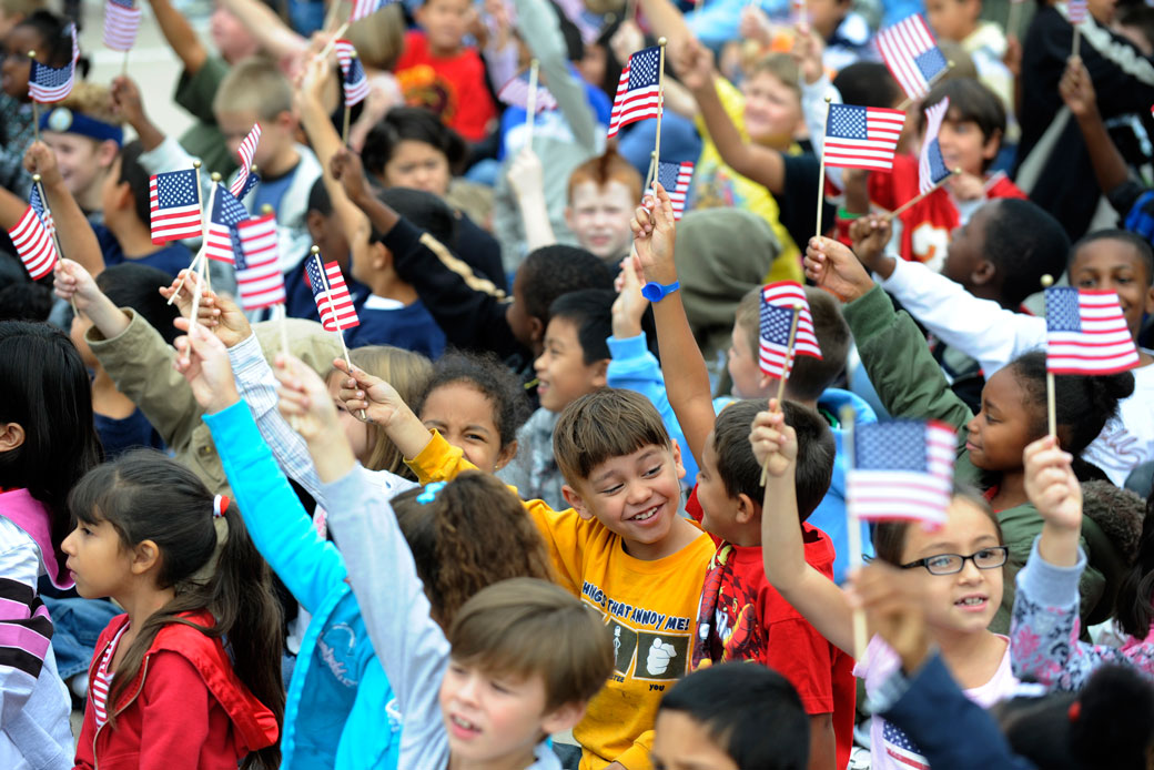 Students wave American flags in front of an elementary school in Colorado, September 2008. (Getty/Andy Cross/The Denver Post)