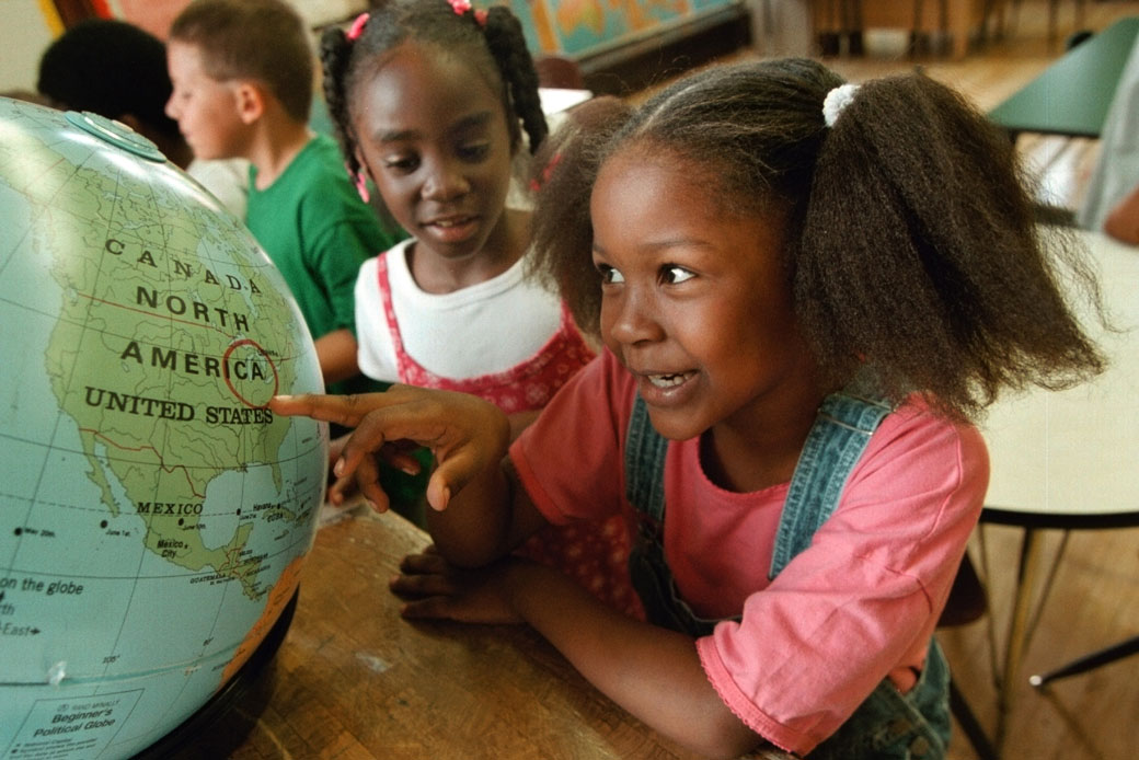 A first-grader in Chicago investigates a circled location on a world globe, August 2000. (Getty/Newsmakers/Tim Boyle)