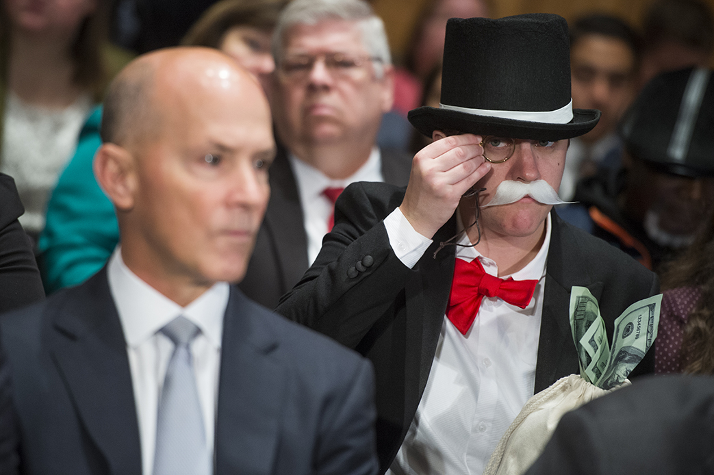 Amanda Werner, who is dressed as Monopoly's Rich Uncle Pennybags, sits behind Richard Smith, left, former CEO of Equifax, during a Senate Banking, Housing, and Urban Affairs Committee hearing on the company's security breach, October 4, 2017. (Getty/CQ Roll Call/Tom Williams)